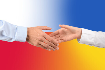 Man and woman shaking hands against flags of Ukraine and Poland