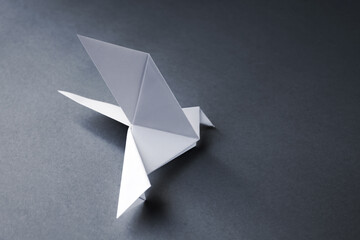 White paper dove origami isolated on a grey background