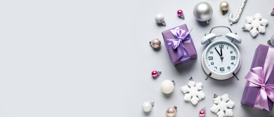 Alarm clock and Christmas decor on light background with space for text