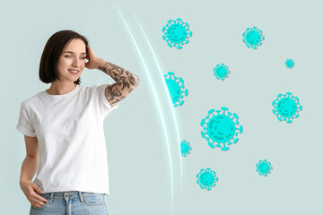Tattooed young woman on light blue background. Concept of strong immunity