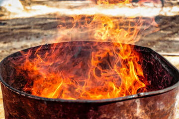 Fototapeta premium Burning fire in a barrel close-up. Bright flame. Open flame heating. Problems with heating and gas.