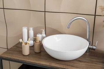 Modern sink and bath accessories near tile wall, closeup