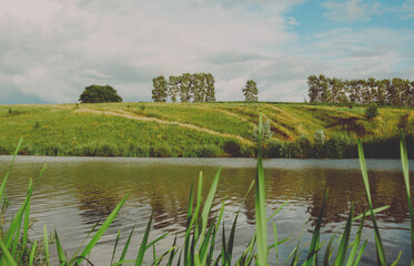 Summer vintage landscape with calm lake and green trees