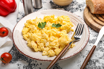 Plate of tasty scrambled eggs on grunge background, closeup