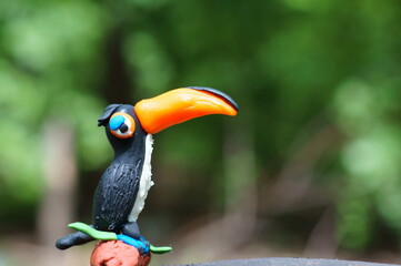 A toy toucan with an orange beak close-up. Tropical birds.