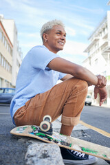 Relax, skateboard and city black man in street of California in summer with Gen Z fashion. Edgy, young and trendy African American skater male in the USA resting on urban road with smile. © Wesley J/peopleimages.com
