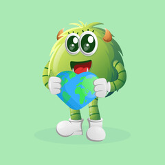Cute green monster holding earth with love shape