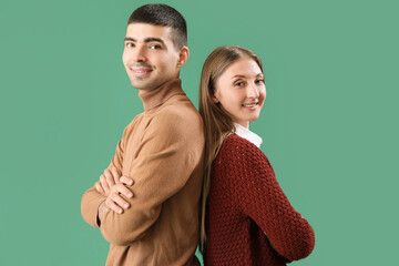 Fashionable young couple in autumn clothes on green background