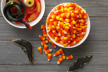 Bowls with Halloween jellies and cookies on dark wooden background