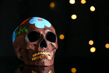 Painted skull for Mexico's Day of the Dead (El Dia de Muertos) on dark background