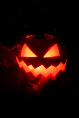 amazing illuminated halloween pumpkin with smoke around on dark background