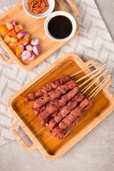 Pork satay with char siu seasoning served with chopped chili, chopped onion, tomato and sweet soy sauce