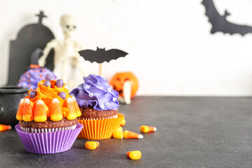 Tasty Halloween cupcakes with candy corns on dark table, closeup