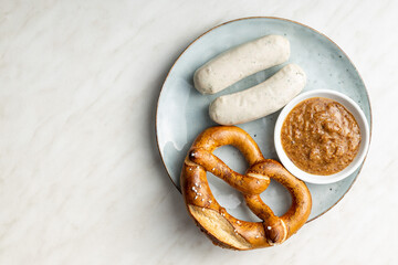 Traditional Bavarian white sausages on plate and pretzes.
