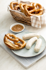 Traditional Bavarian white sausages on plate and pretzes.