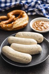 Traditional Bavarian white sausages on plate and pretzes.