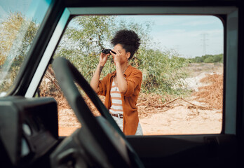Black woman with binocular for view, travel and adventure on road trip in countryside desert....