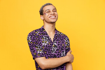 Young happy confident happy smiling cheerful fun gay man wearing purple animal print shirt look camera isolated on bright plain yellow color background studio portrait. Lifestyle lgbtq pride concept. - obrazy, fototapety, plakaty