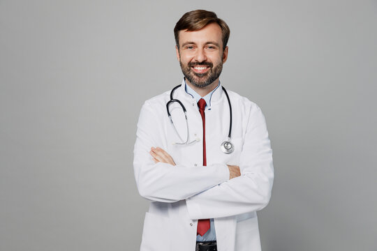 Male Doctor Man Wears White Medical Gown Suit Stethoscope Work In Hospital Hold Hands Crossed Folded Look Camera Isolated On Plain Grey Color Background Studio Portrait. Healthcare Medicine Concept.