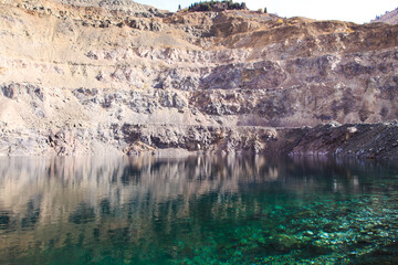 Flooded quarry in the mountains. Location for mining. Beautiful turquoise lake. Kyrgyzstan, Ak-Tuz.