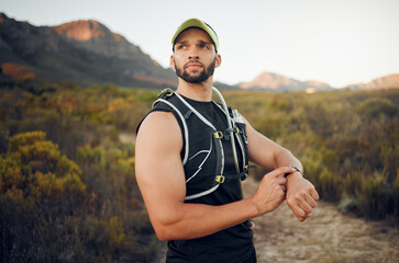 Fototapeta premium Fitness, man and smart watch time for mountain running, exercise workout or healthy hiking trail training. Focus runner monitor stopwatch, check steps and cardio progress for wellness goals in nature