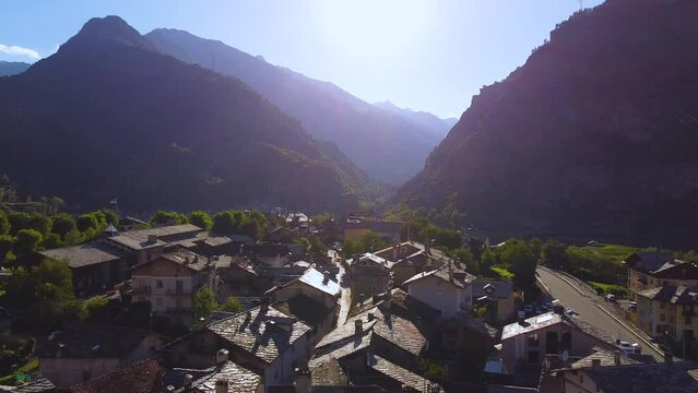 Italian alps village on a sunny day, aerial drone view with left motion