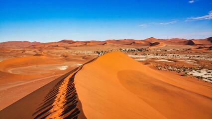 Orange sand dunes under blue sky in dry desert in Namibia, Southern Africa
