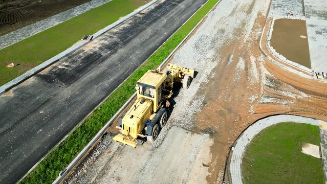 A powerful grader is leveling the road at a construction site. view from above. drone photography. Earthworks with heavy equipment at the construction site.