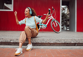 Black woman in city, listen to music on headphones and relax on street sidewalk waiting for a taxi. Girl streaming podcast, musician online and happy dance song from smartphone 5g internet connection