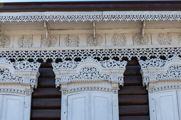 A fragment of a wooden house decorated with openwork wood carvings - obrazy, fototapety, plakaty