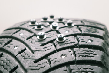 Worn tire tread, winter studded tire - wheel repair service. Renew Lost studs. Old winter studded tire close up. Used snow tire with missing steal studs closeup.