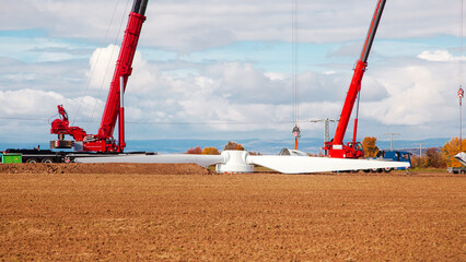 Construction site. dismantling of an old windturbine by crane. Farmland with construction work at...