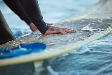 Surf, ocean surfing and hand of man on surfboard in sea water. Summer water sport fitness, male...