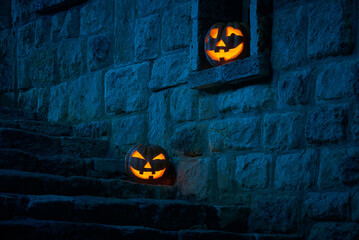 Halloween pumpkins jack p lantern in the yard of an old castle at night in the bright moonlight - obrazy, fototapety, plakaty