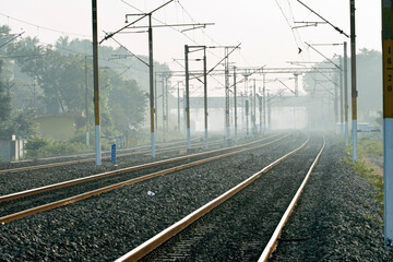 Railway in the fog. Indian railway track in winter season. Foggy winter morning. Mist in the train tracks. - Powered by Adobe