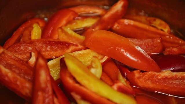 Close-ups sliced fresh raw organic sweet pepper are boiled in boiling tomato juice. Preparation of lecho salad for winter, according to traditional recipe. Preserving homegrown vegetables for winter