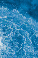 Dark blue sea surface with waves, splash