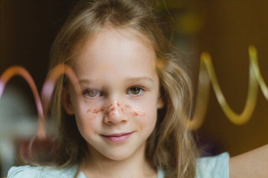 Happy little girl with glitters on face