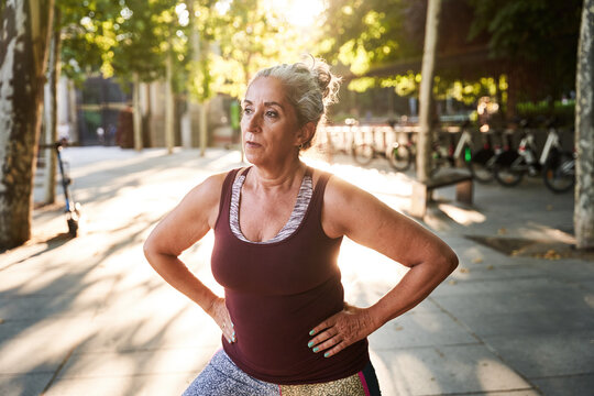 Senior sportswoman exercising at street