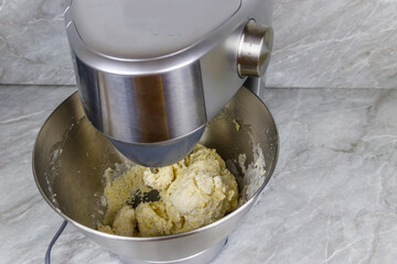 Kneading dough in the modern kitchen machine on a table