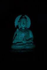 WOODEN BUDDHA STATUE IN LUMINANCE LIGHTING.