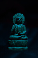 WOODEN BUDDHA STATUE IN LUMINANCE LIGHTING.
