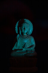 WOODEN BUDDHA STATUE IN LUMINANCE LIGHTING.