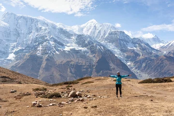 Photo sur Plexiglas Annapurna A woman on the Annapurna Circuit, Himalaya, Nepal. Annapurna in the back, covered with snow. Altitude, huge mountains. Freedom