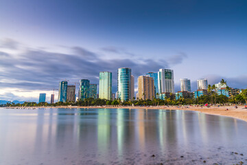 Fototapeta na wymiar hawaii beach with city skyline at sunset.