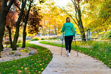 Nordic walking - woman training in city park 