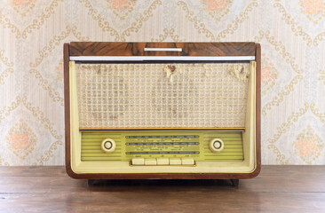 Vintage radio gramophone (radio) on the background of old wallpaper.