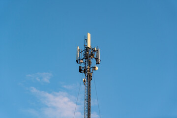 Telecommunications antennas and satellite communication technology. Mobile network on blue sky background.
