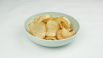 Pile of healthy sweet potato chips in a bowl isolated on a white background.