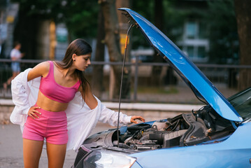 Woman with broken car on the road. Look for help.